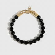 14k gold plated men's black agate bead bracelet, shown on a plain background.