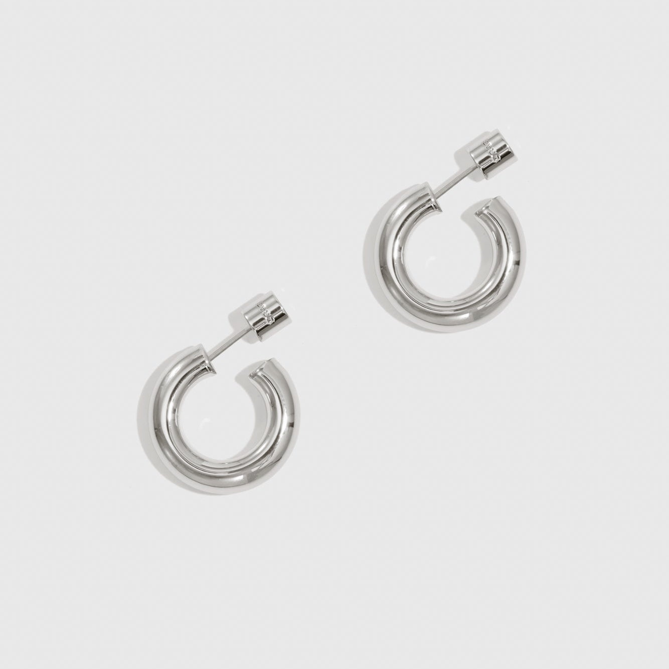 Silver plated mini hollow hoop earrings, shown on a plain background.