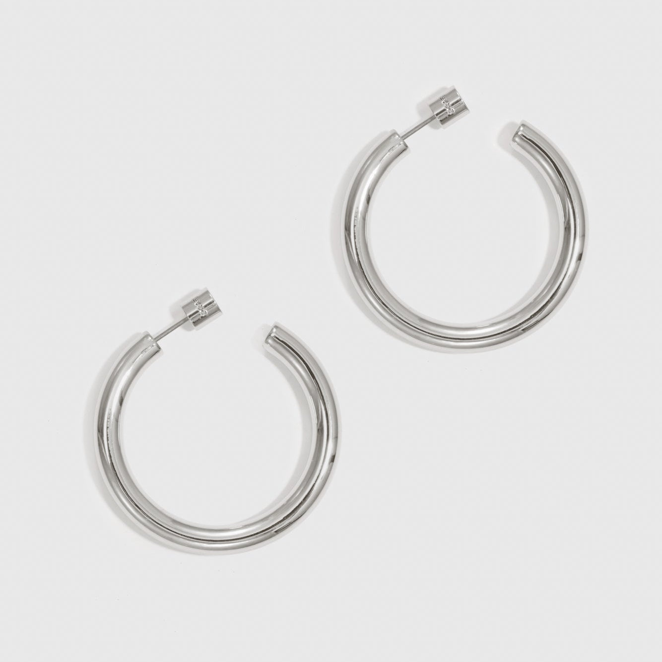 Silver plated small hollow hoop earrings, shown on a plain background.