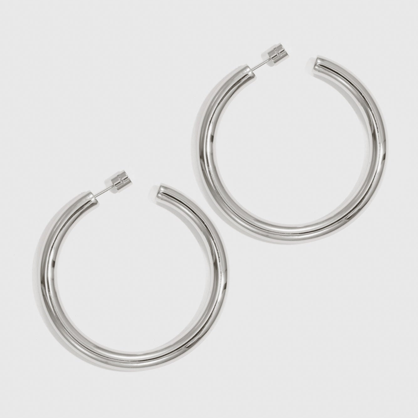 Silver plated medium hollow hoop earrings, shown on a plain background.