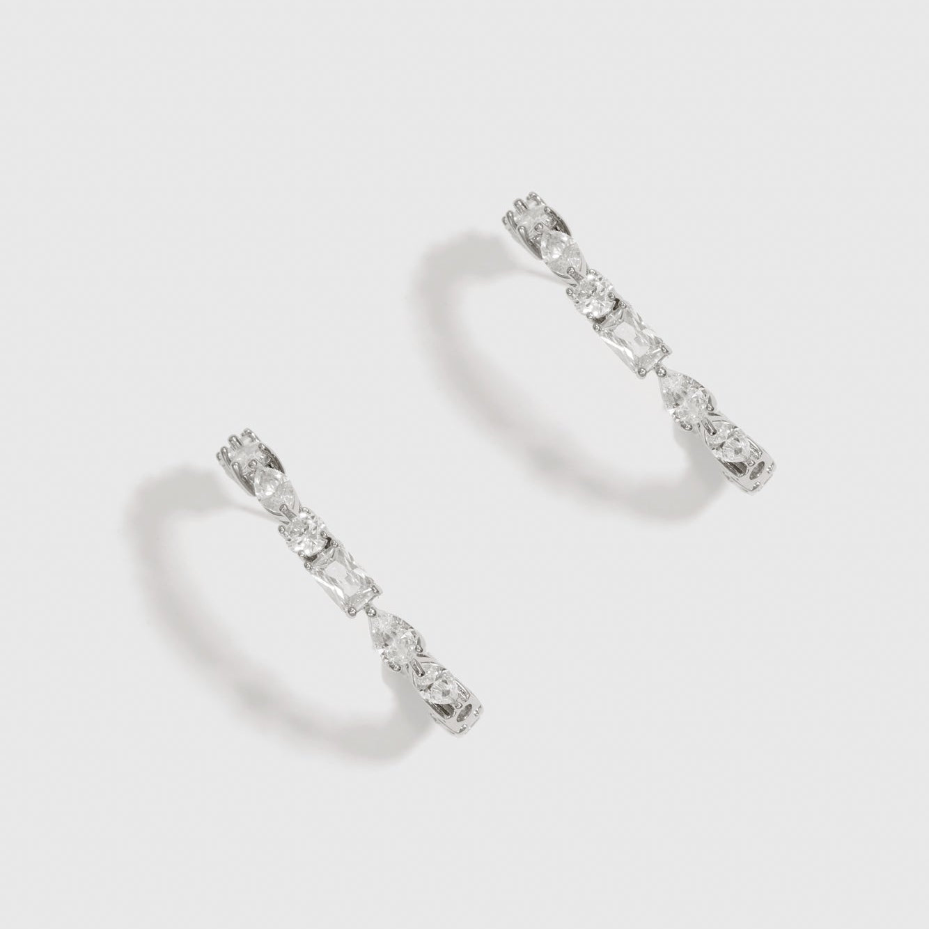 Silver plated multi-cut hoop earrings with cubic zirconia, shown on a plain background.