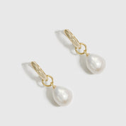 14k gold plated sterling silver 925 baroque pearl huggie earrings with baroque pearls, shown on a plain background.