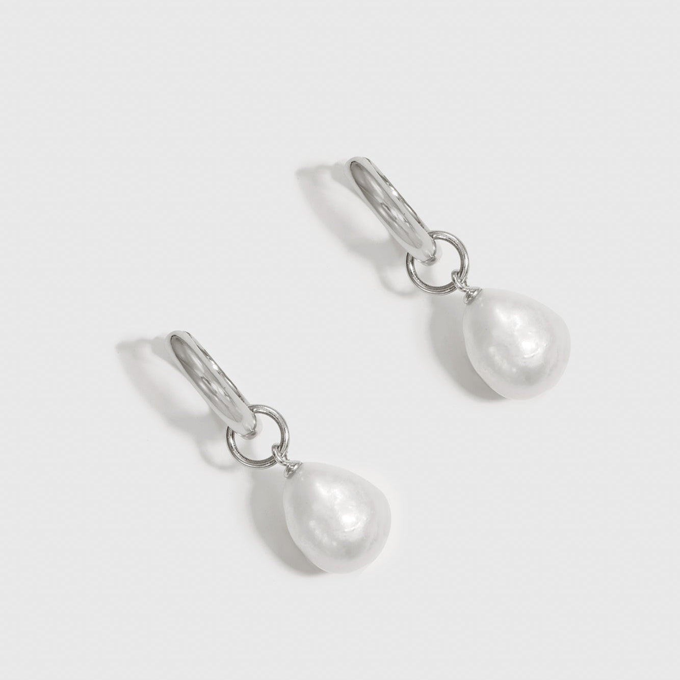 Sterling silver 925 baroque pearl huggie earrings with baroque pearls, shown on a plain background.