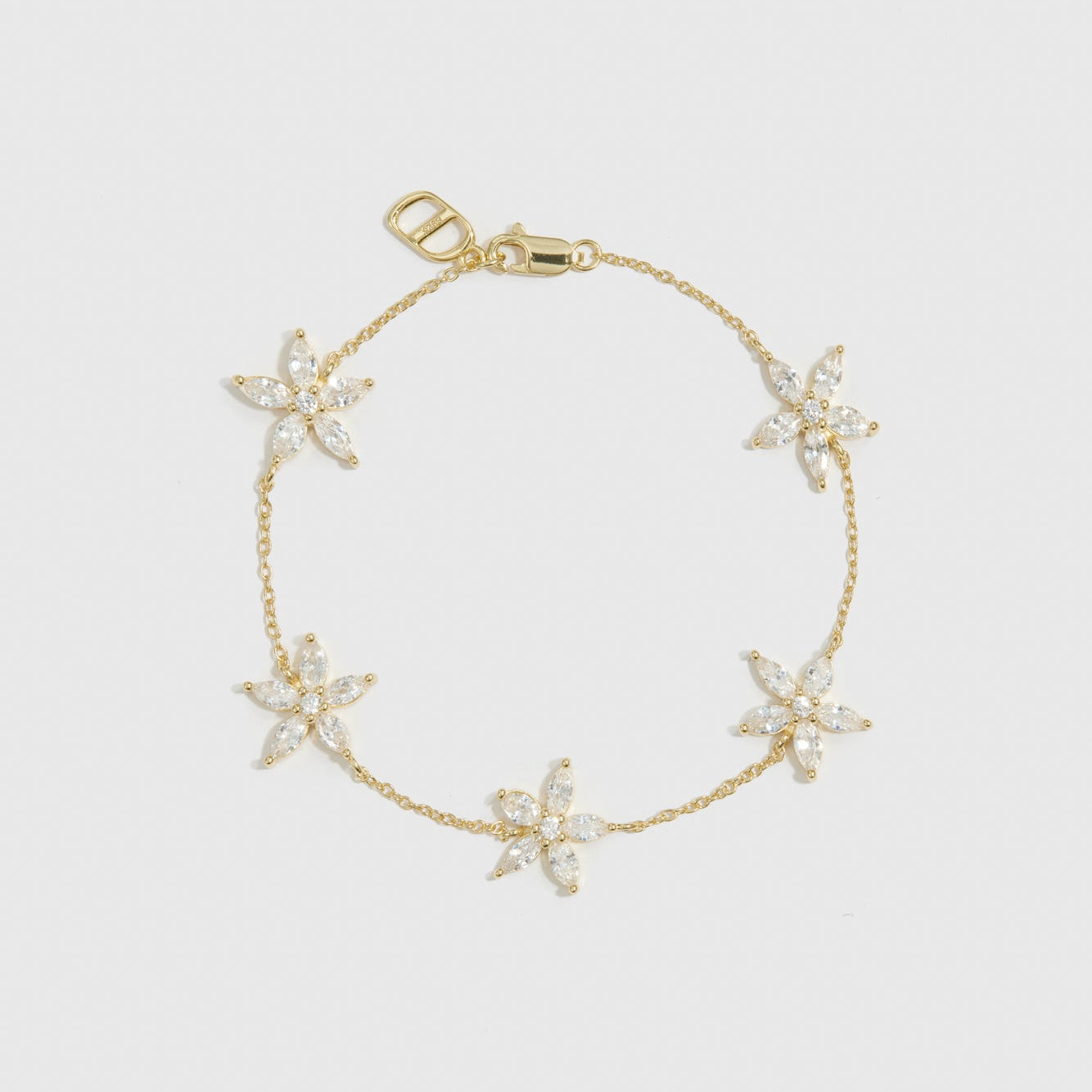 14k gold plated sterling silver 925 flower multi bracelet with cubic zirconia flowers, shown on a plain background.