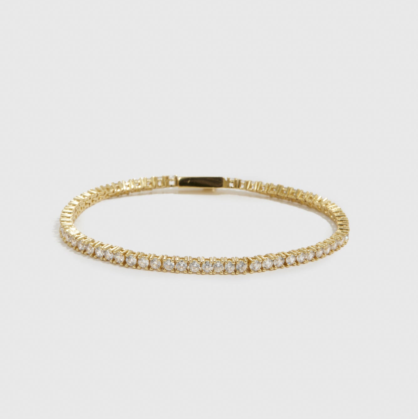 14k gold plated dainty tennis bracelet with cubic zirconia, shown on a plain background.