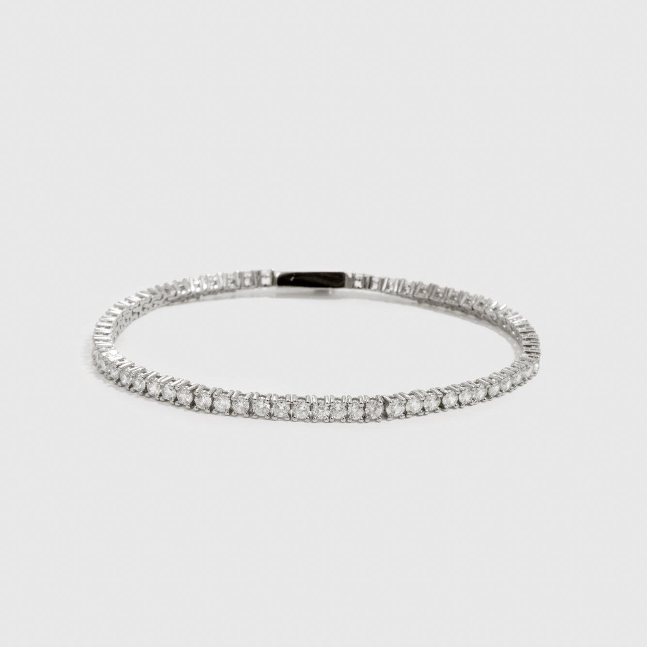 Silver plated dainty tennis bracelet with cubic zirconia, shown on a plain background.