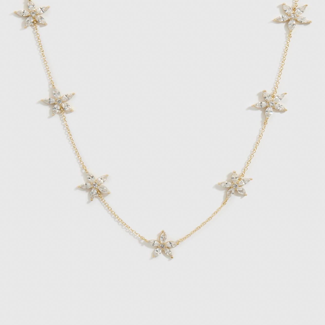 14k gold plated sterling silver 925 flower multi necklace with cubic zirconia flowers, shown on a plain background.