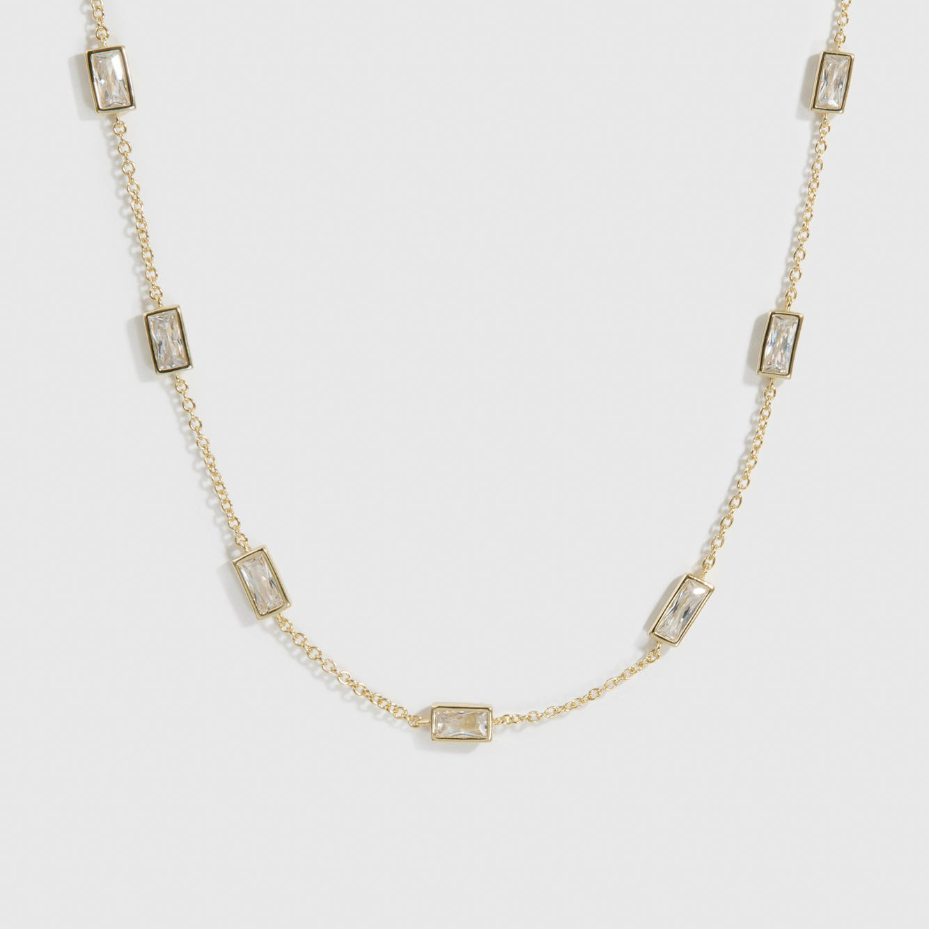 14k gold plated sterling silver 925 baguette-cut multi bezel necklace with cubic zirconia, shown on a plain background.