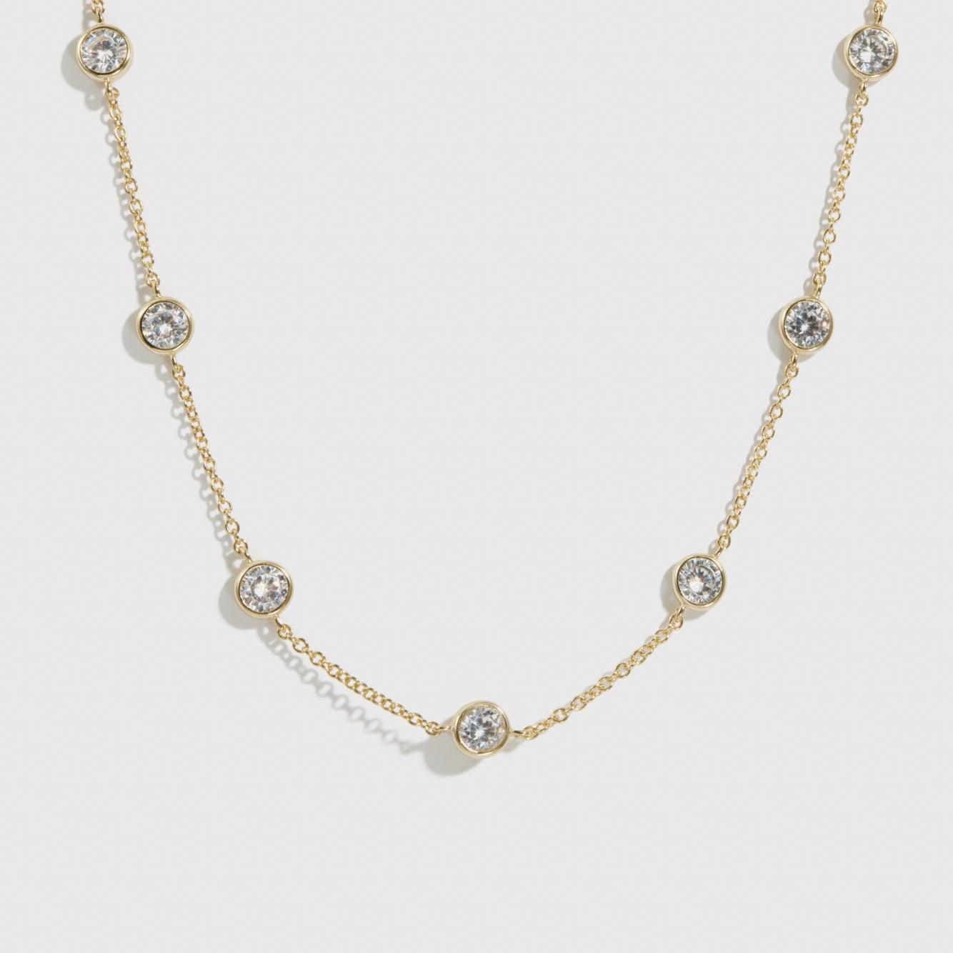 14k gold plated sterling silver 925 round-cut multi bezel necklace with cubic zirconia, shown on a plain background.
