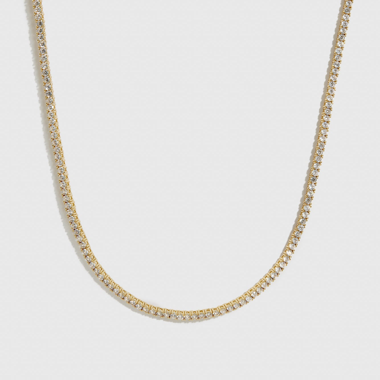 14k gold plated dainty tennis necklace with cubic zirconia, shown on a plain background.