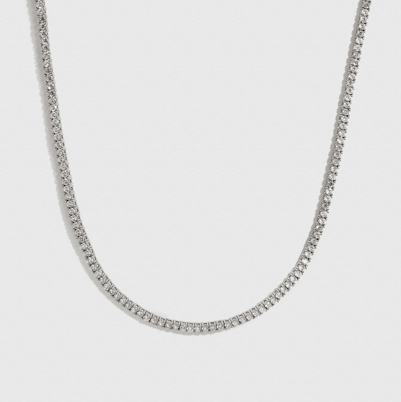 Silver plated dainty tennis necklace with cubic zirconia, shown on a plain background.