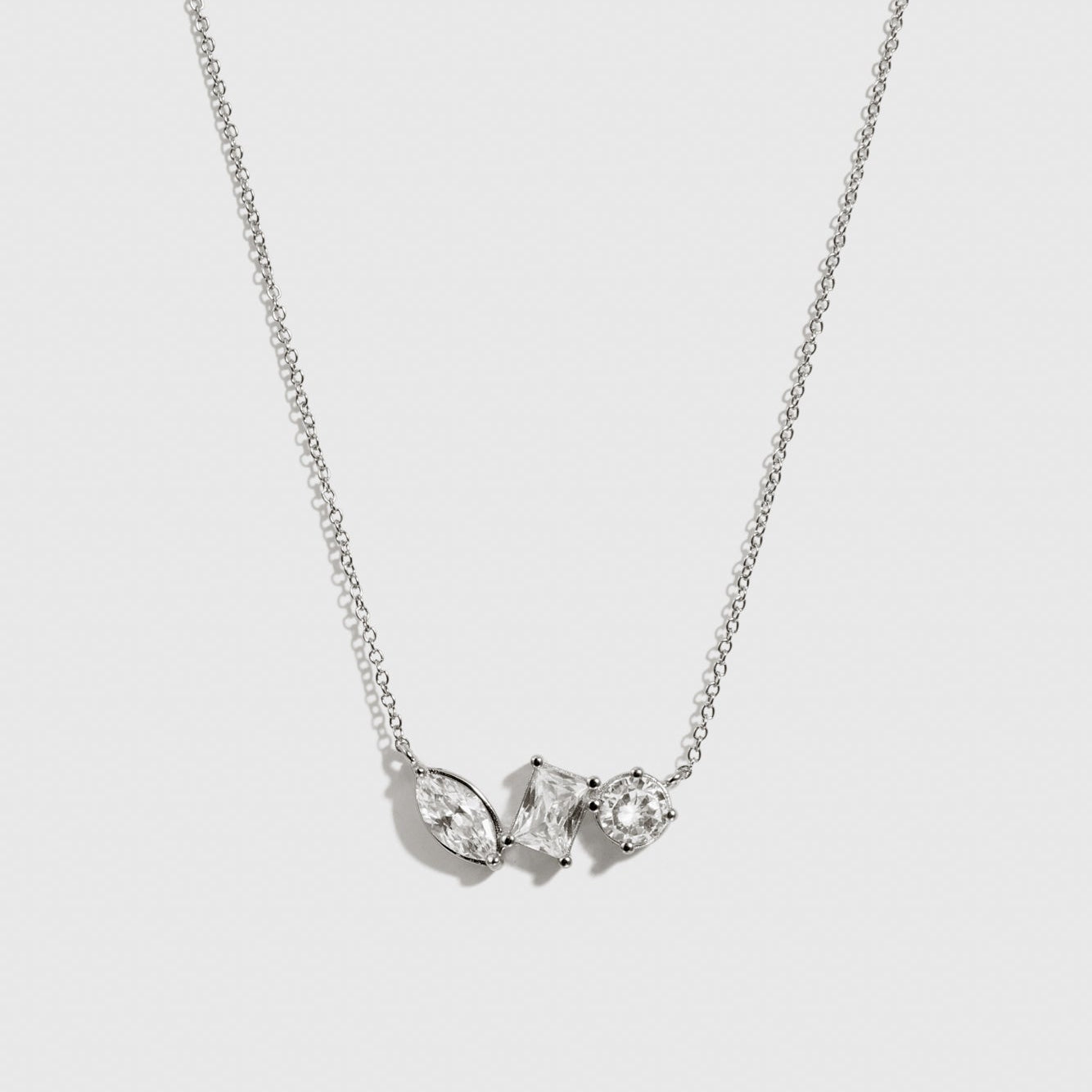 Sterling silver 925 trio-cut dainty necklace with cubic zirconia, shown on a plain background.