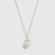 14k gold plated sterling silver 925 solitaire baroque pearl necklace with a baroque pearl, shown on a plain background.