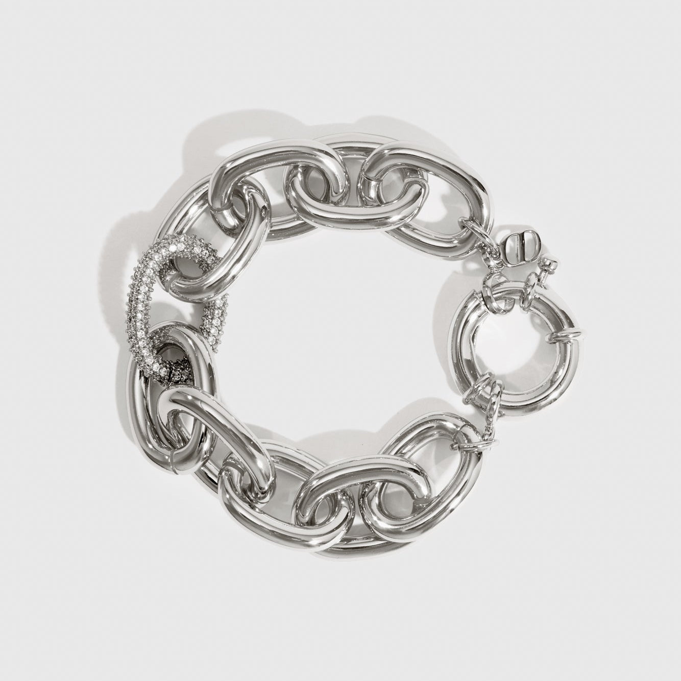 Silver plated oval link pavé bracelet with pavé cubic zirconia, shown on a plain background.
