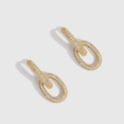 14k gold plated oval link pavé pendant hoops with pavé cubic zirconia, shown on a plain background.