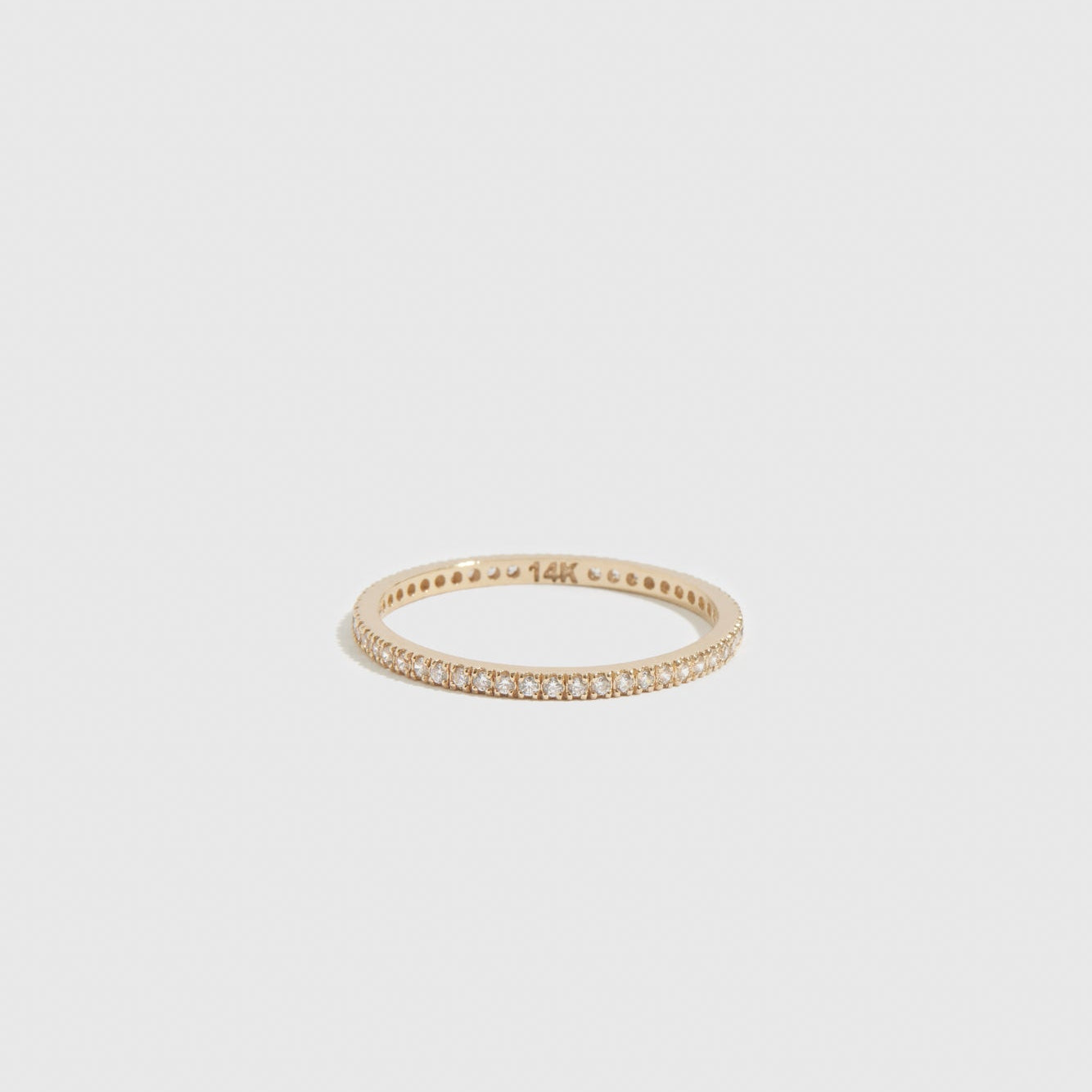 14k solid gold eternity pavé ring with cubic zirconia or lab-grown diamonds, shown on a plain background.