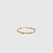 14k solid gold eternity pavé ring with cubic zirconia or lab-grown diamonds, shown on a plain background.