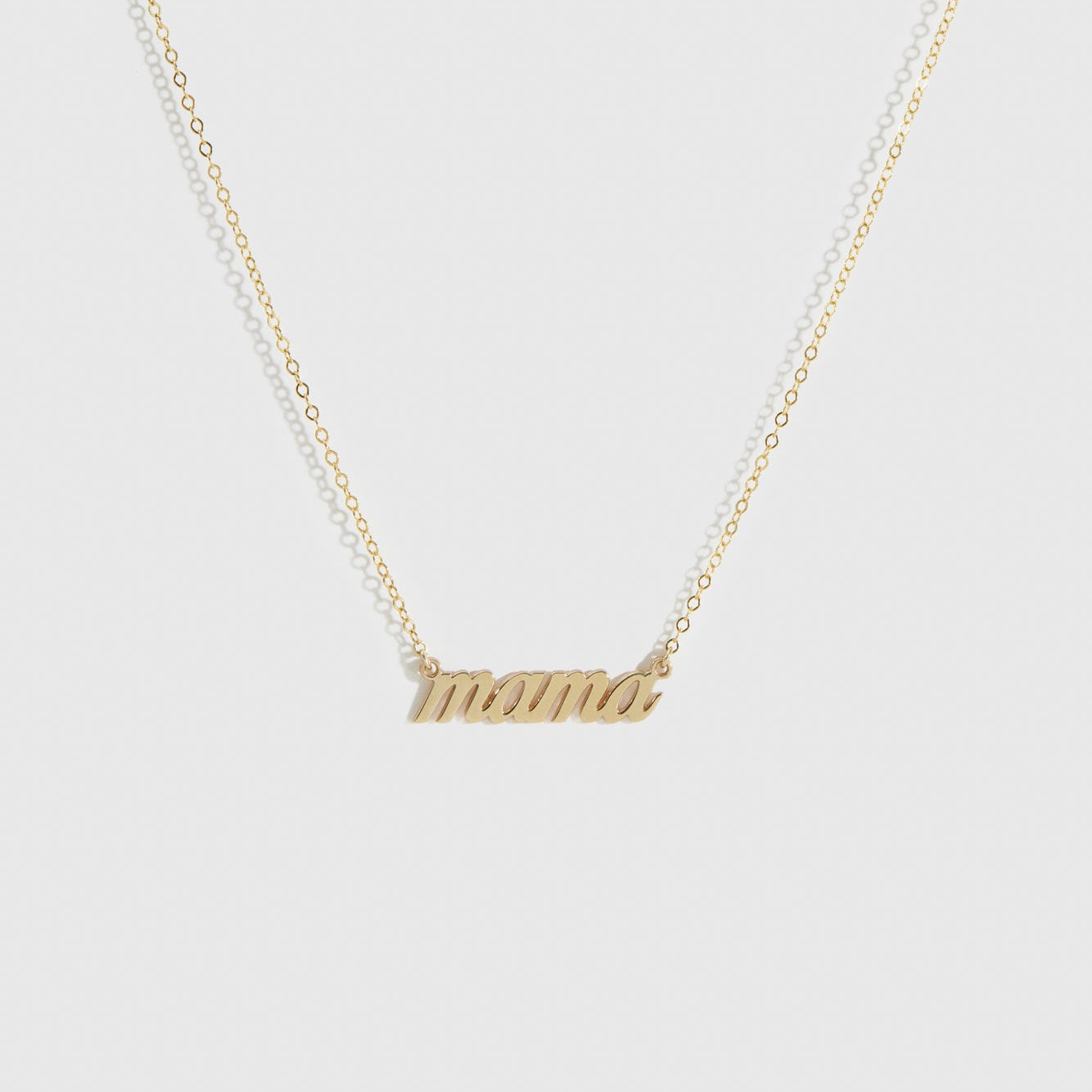 14k solid gold cursive font Mama necklace, shown on a plain background.