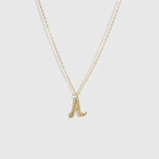 14k solid gold cursive font letter pendant necklace, shown on a plain background.