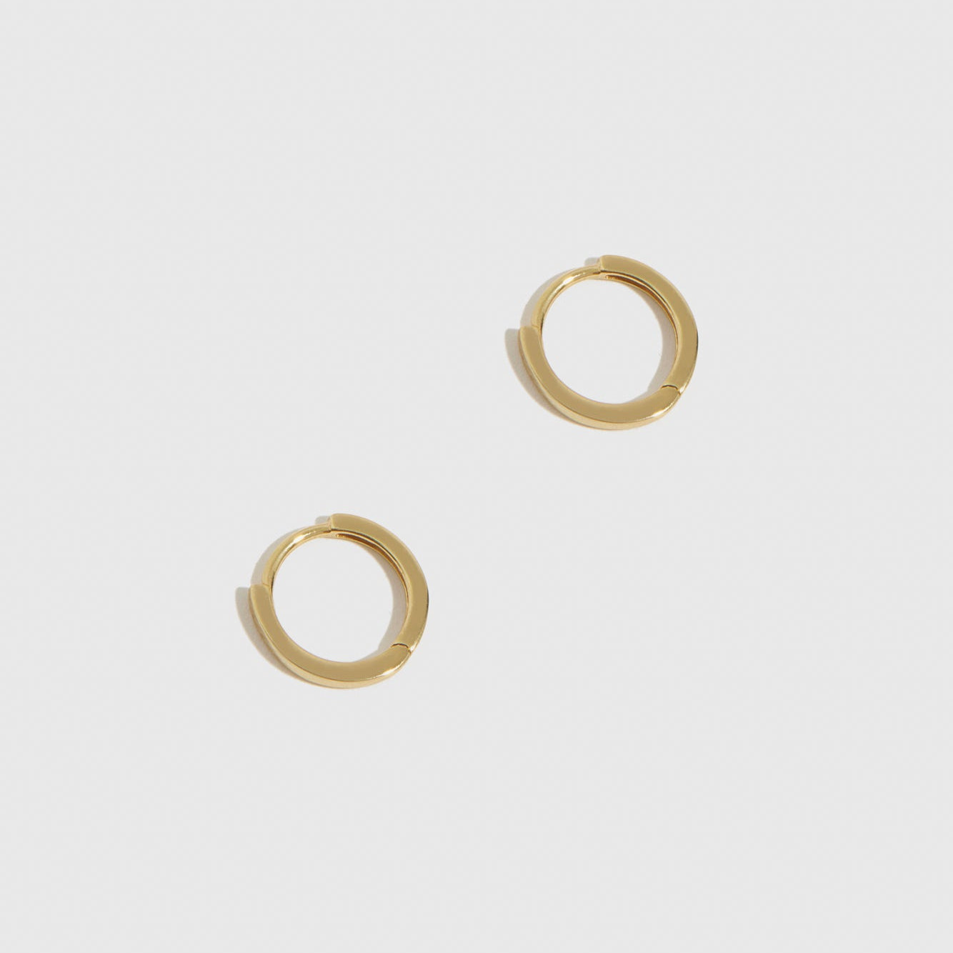 14k solid gold classic huggie hoops, shown on a plain background.