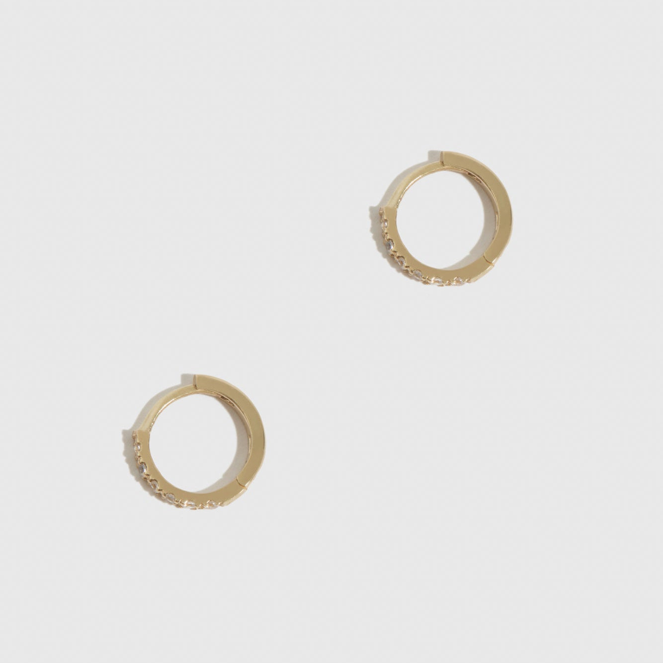 14k solid gold mini pavé huggie hoops with cubic zirconia or lab-grown diamonds, shown on a plain background.