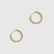14k solid gold classic huggie pavé hoops with cubic zirconia or lab-grown diamonds, shown on a plain background.