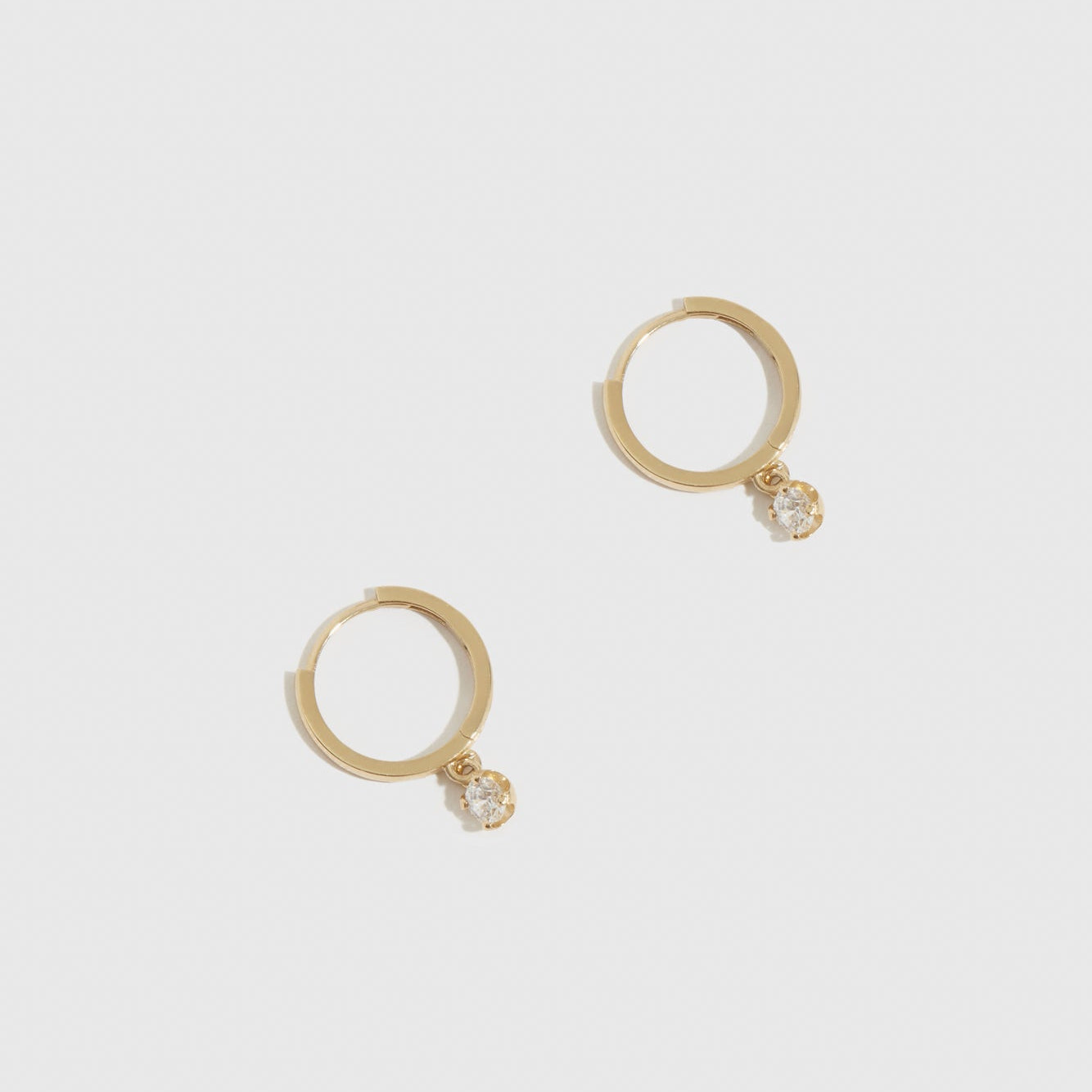 14k solid gold solitaire huggie hoops with cubic zirconia or lab-grown diamonds, shown on a plain background.