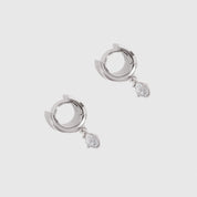 Silver hoop earrings with small stones on a light gray background