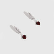 Pair of earrings with red gemstones on a white background