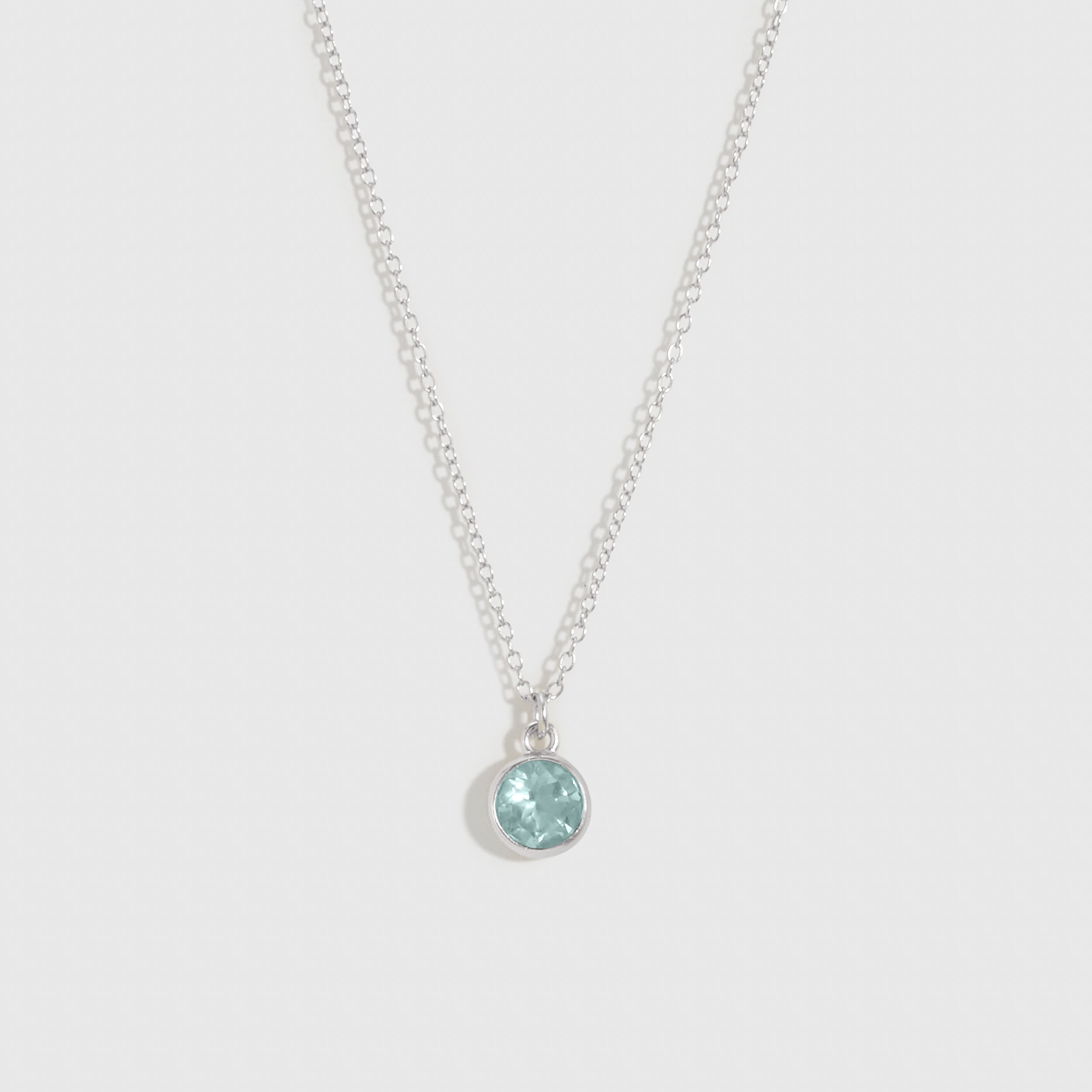 Necklace with a round pendant on a light gray background