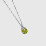 Necklace with a green gemstone pendant on a white background