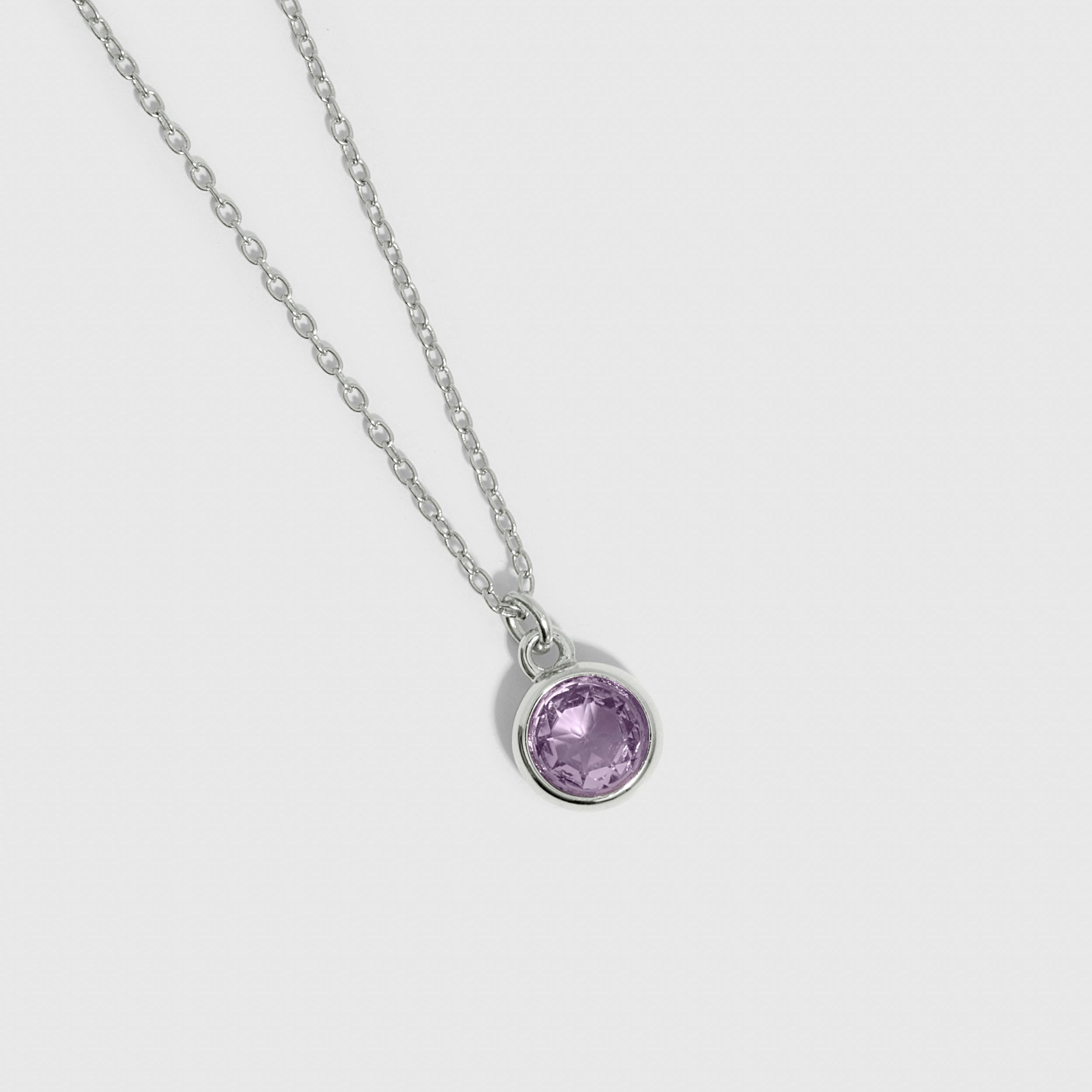 Necklace with a purple gemstone pendant on a light gray background