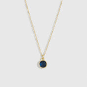 Necklace with a green pendant on a light gray background