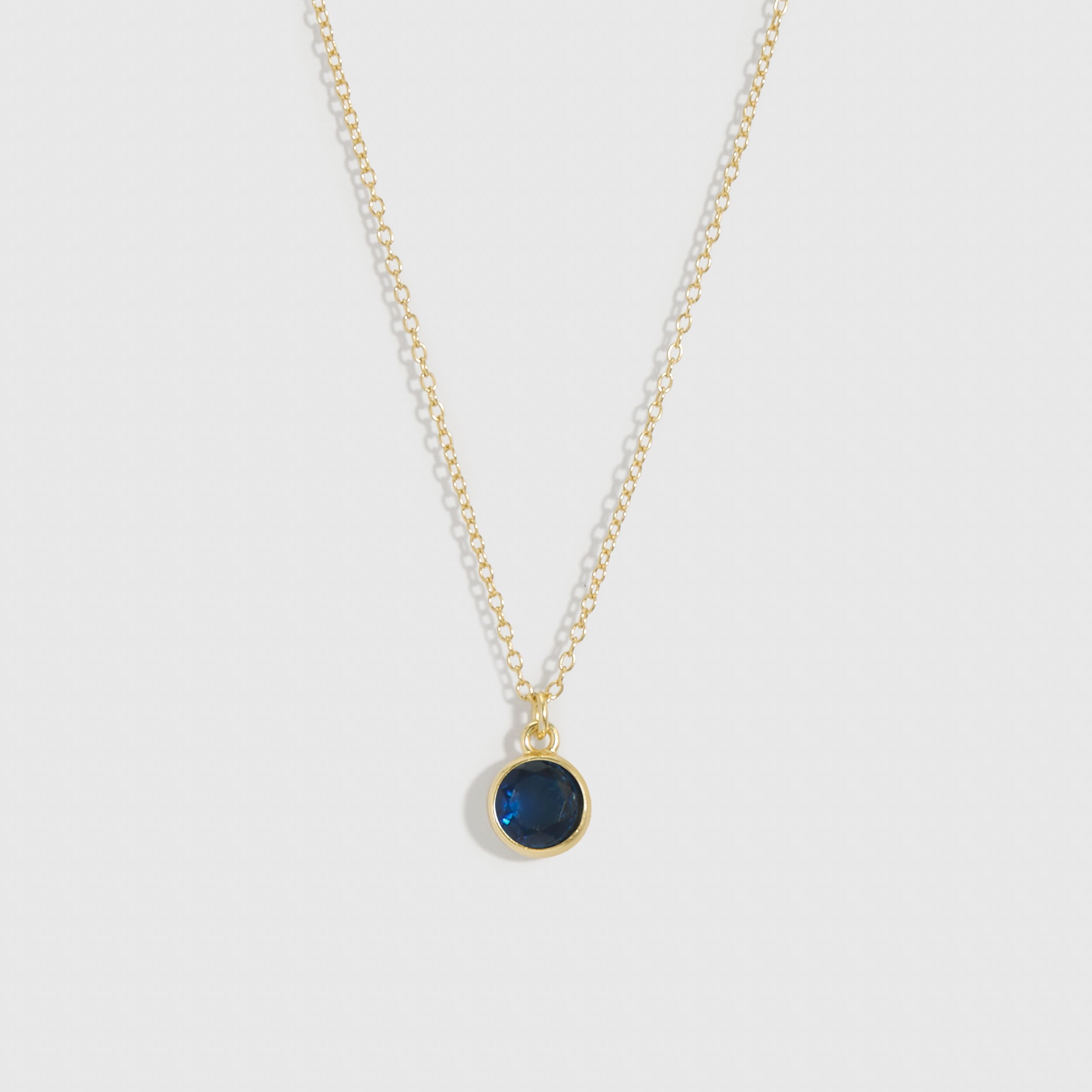 Necklace with a green pendant on a light gray background