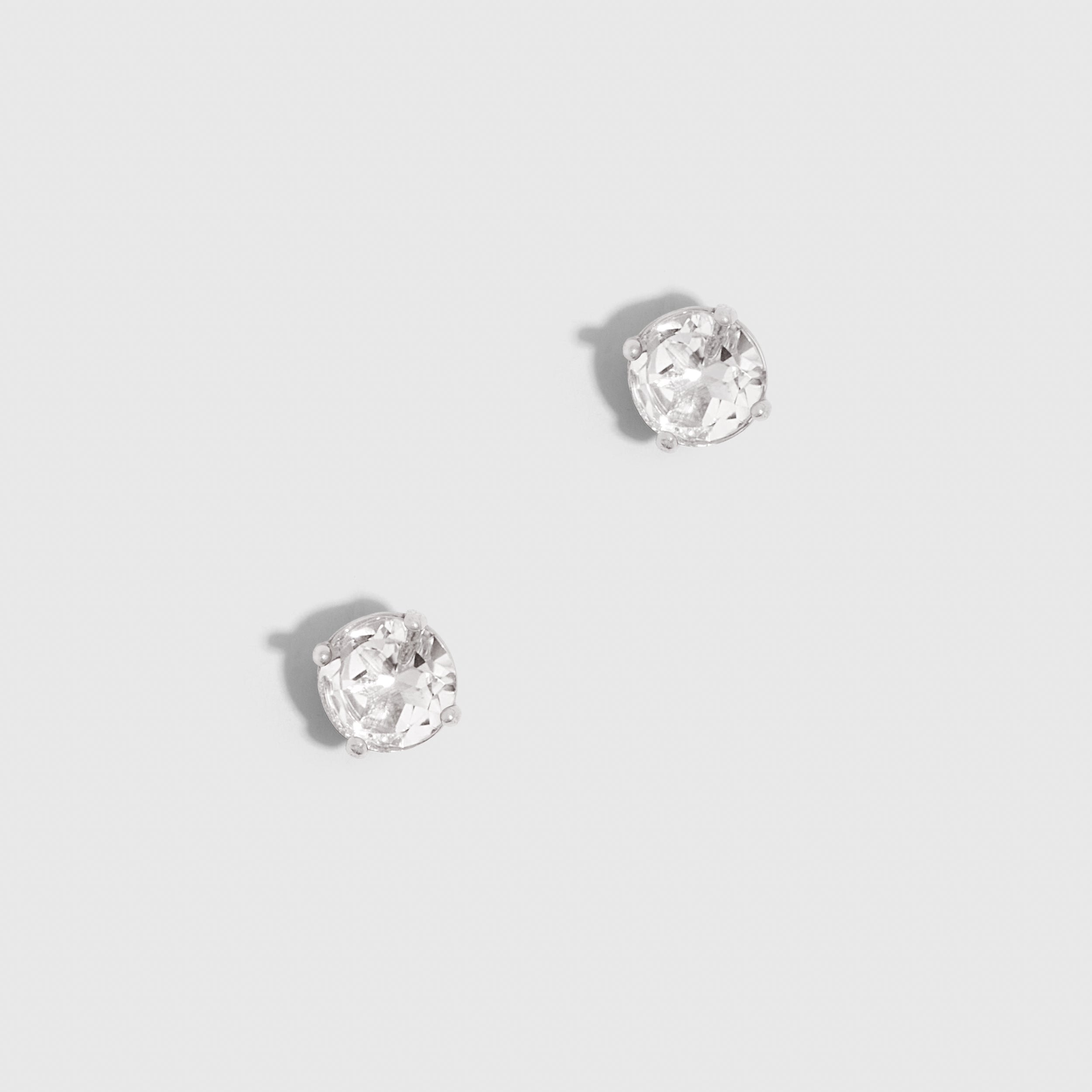 Pair of silver stud earrings on a light gray background