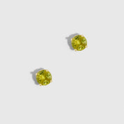 Two round green gemstones on a light gray background