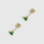 Gold earrings with green gemstones on a white background