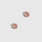 Pair of earrings with pink gemstones on a light gray background
