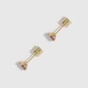 Gold earrings with pink gemstones on a light gray background