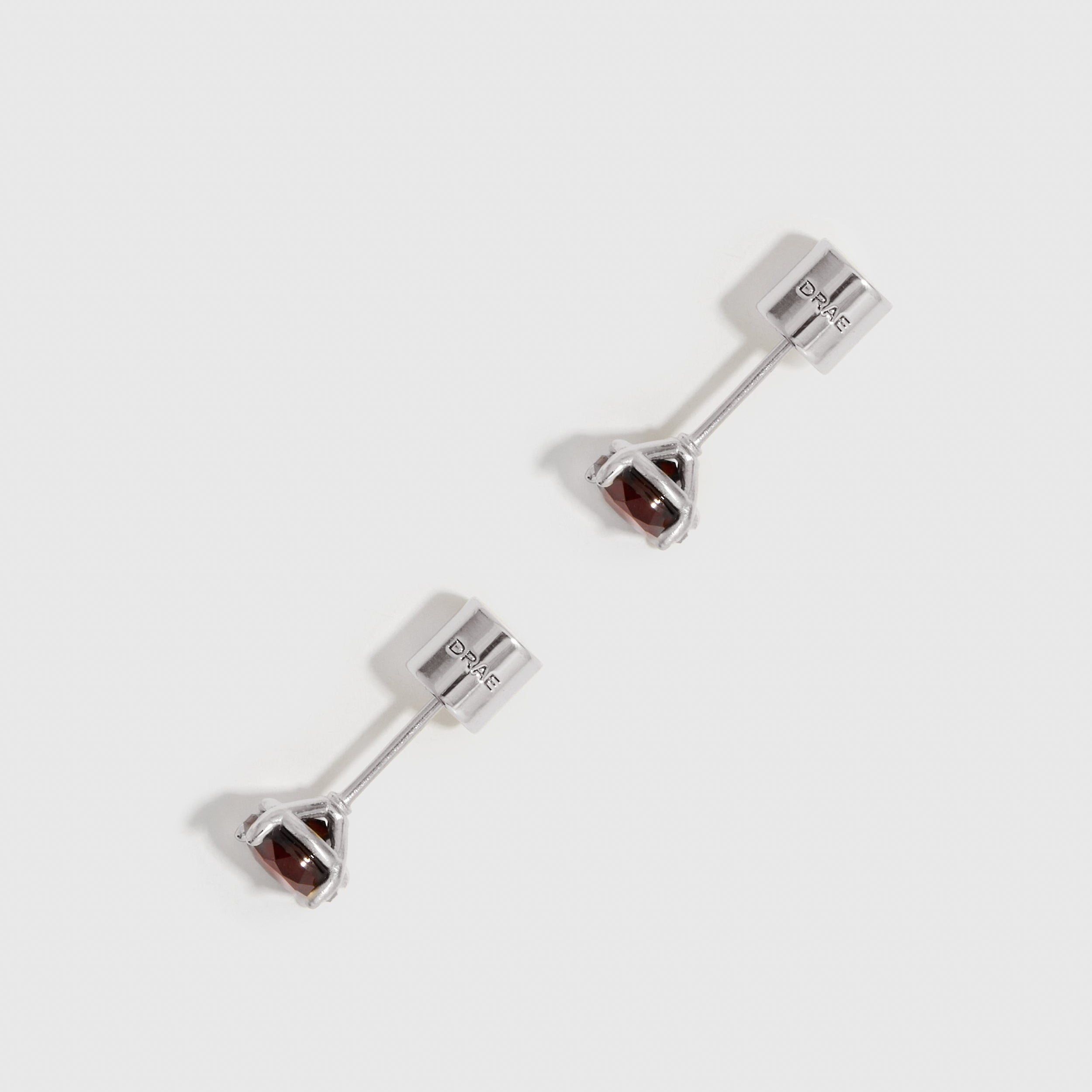 Pair of silver earrings with gemstones on a white background