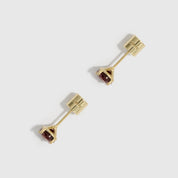 Gold earrings with gemstones on a white background