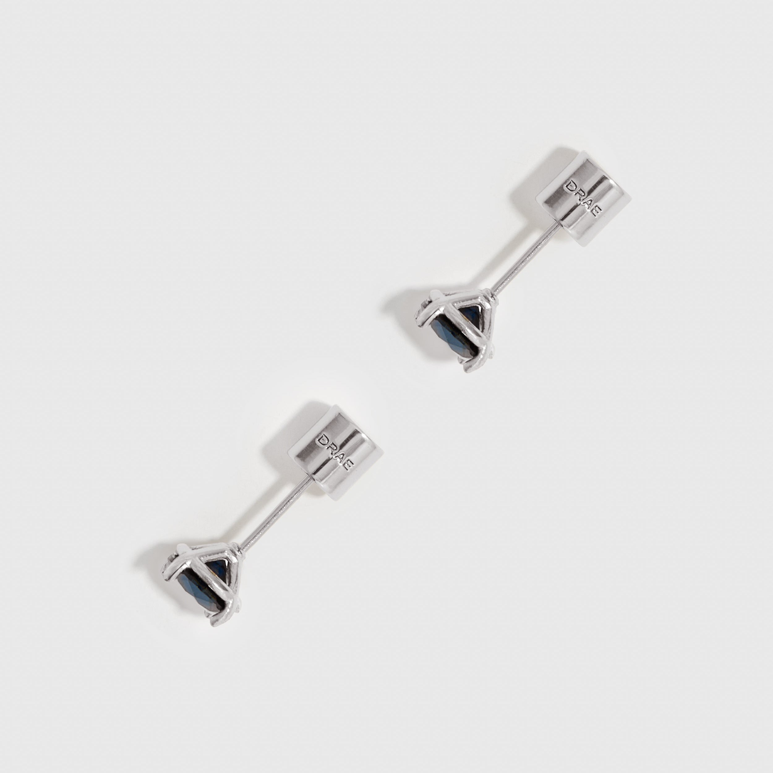 Pair of silver stud earrings on a white background