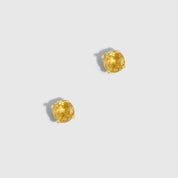 Pair of gold lion head earrings on a light gray background