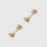 Gold earrings on a light gray background