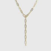 14k gold plated maximalist paper clip lariat necklace with a pavé cubic zirconia clasp, shown on a plain background.