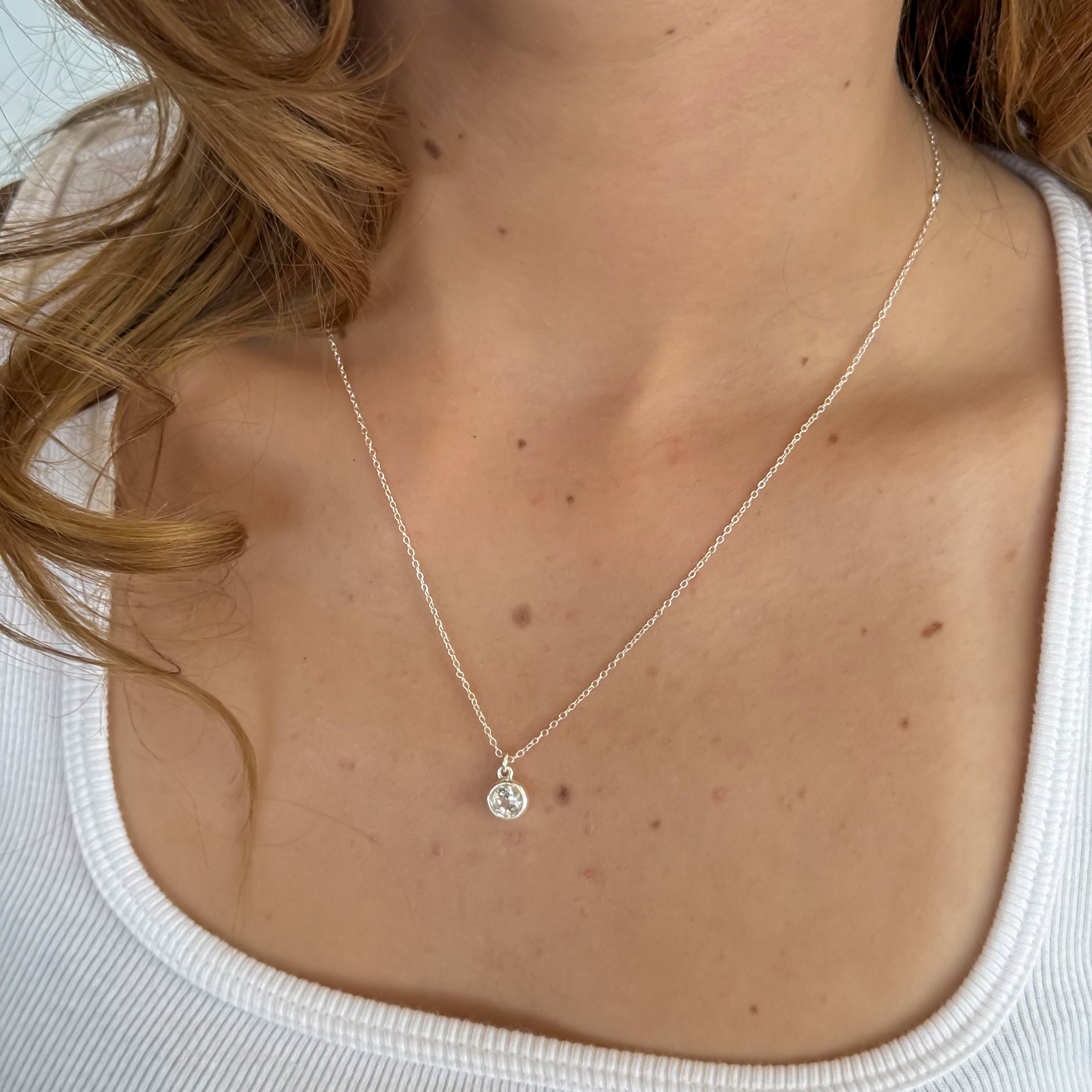Necklace with a small pendant worn by a person