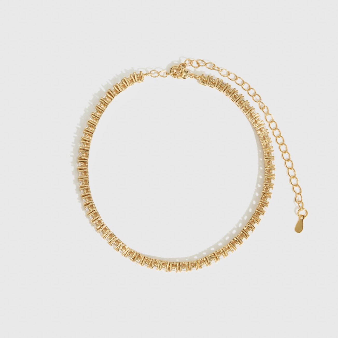 14k gold plated thin tennis anklet with cubic zirconia, shown on a plain background.