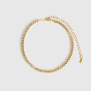 14k gold plated thin tennis anklet with cubic zirconia, shown on a plain background.