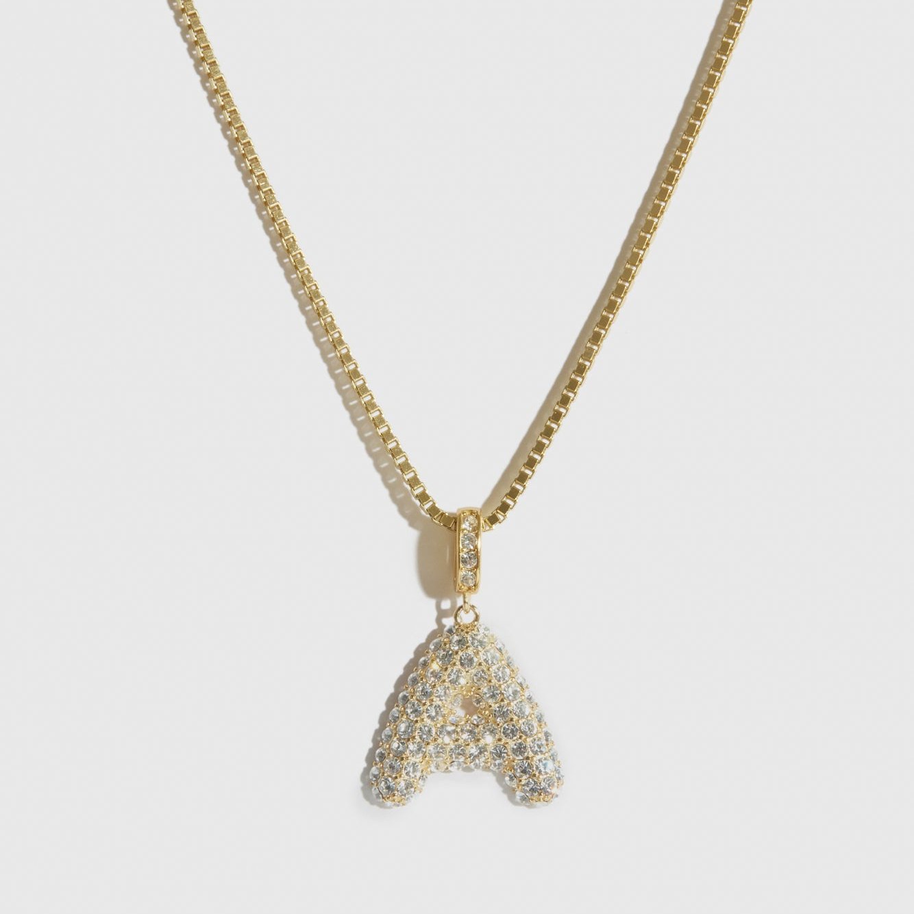 14k gold plated pavé bubble letter pendant necklace with cubic zirconia, shown on a plain background.