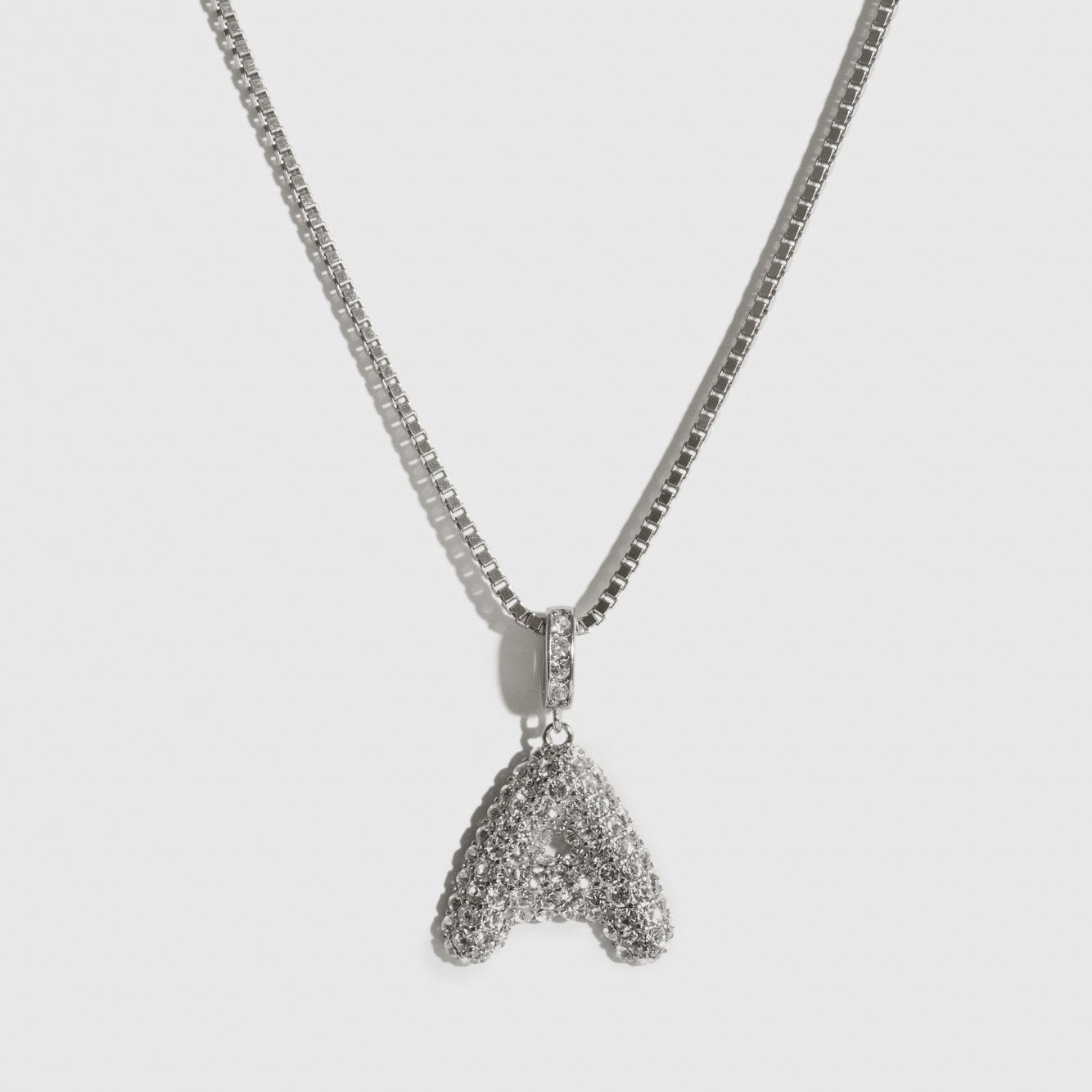 Silver plated pavé bubble letter pendant necklace with cubic zirconia, shown on a plain background.